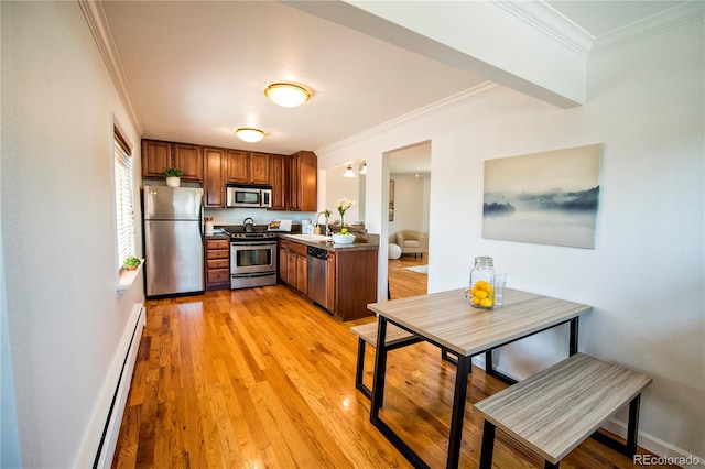 kitchen featuring stainless steel appliances, light hardwood / wood-style floors, ornamental molding, sink, and a baseboard heating unit