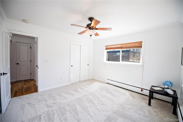 unfurnished bedroom featuring a baseboard radiator, a closet, ceiling fan, crown molding, and light colored carpet