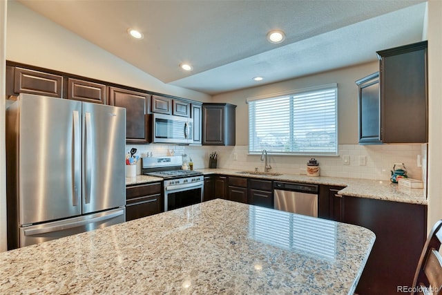 12718 Windingwalk Dr, Peyton, CO 80831 - kitchen with stainless steel appliances, a sink, dark brown cabinets, tasteful backsplash, and recessed lighting