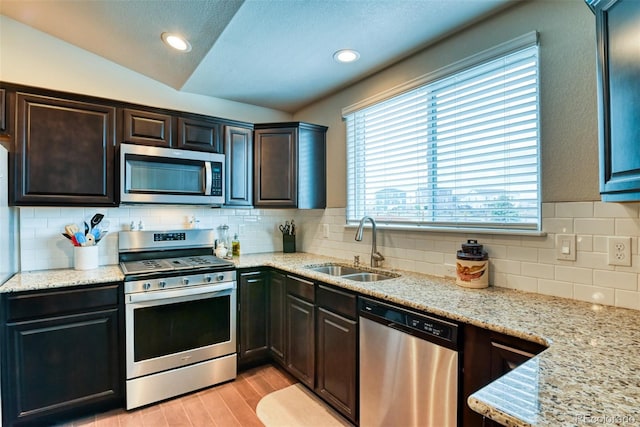 12718 Windingwalk Dr, Peyton, CO 80831 - kitchen with stainless steel appliances, a sink, decorative backsplash, light wood finished floors, and dark brown cabinets