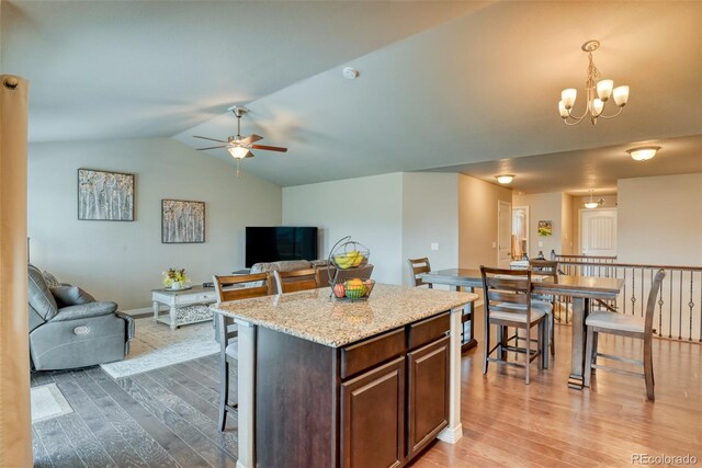 12718 Windingwalk Dr, Peyton, CO 80831 - kitchen with open floor plan, wood finished floors, ceiling fan, a center island, and lofted ceiling