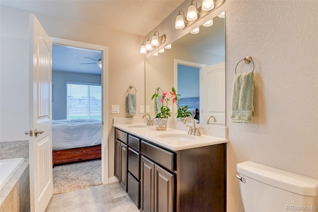 12718 Windingwalk Dr, Peyton, CO 80831 - full bathroom with double vanity, ensuite bathroom, tiled tub, toilet, and ceiling fan
