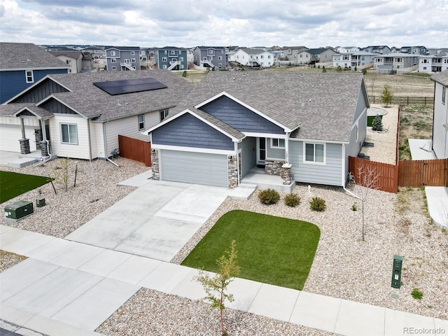 12718 Windingwalk Dr, Peyton, CO 80831 - view of front facade featuring a residential view, stone siding, an attached garage, driveway, and a shingled roof