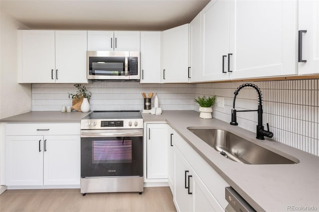 kitchen featuring light hardwood / wood-style flooring, stainless steel appliances, white cabinetry, and sink