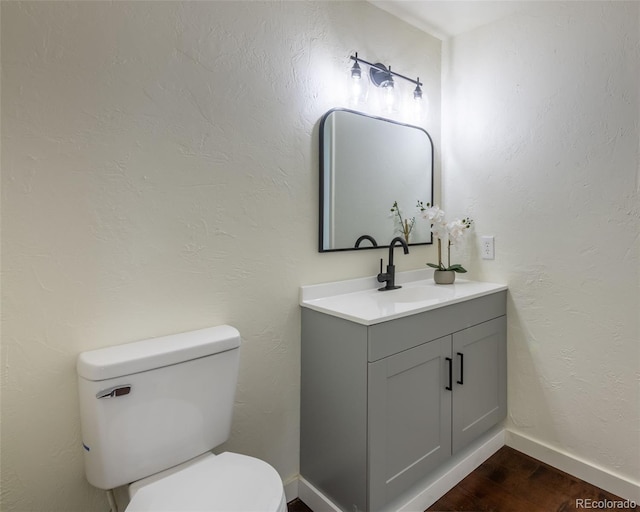 bathroom featuring vanity, hardwood / wood-style flooring, and toilet