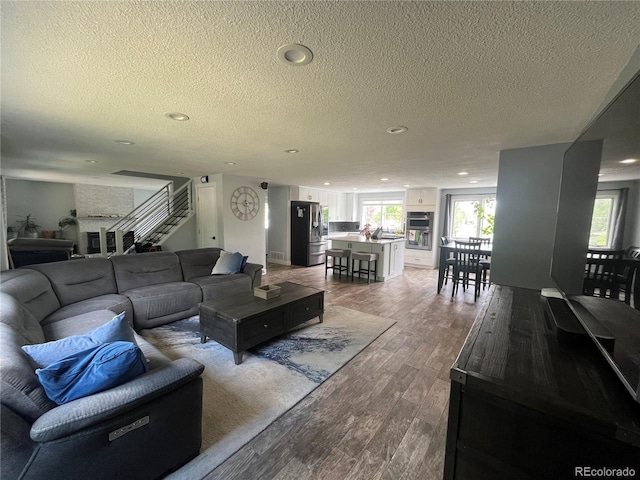 1158 E Easter Ct, Centennial, CO 80122 - living area featuring a textured ceiling, wood finished floors, healthy amount of natural light, stairs, and recessed lighting