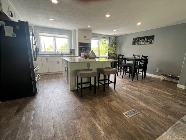 1158 E Easter Ct, Centennial, CO 80122 - kitchen featuring freestanding refrigerator, a kitchen island, dark wood-style flooring, recessed lighting, and white cabinetry