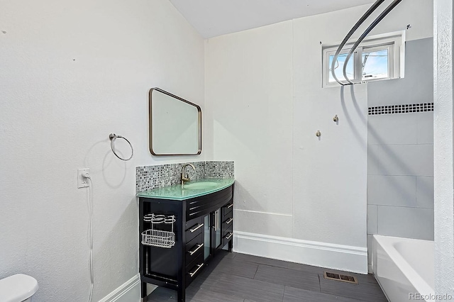 full bathroom with toilet, vanity, visible vents, baseboards, and shower / washtub combination