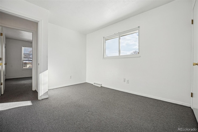 empty room featuring dark carpet