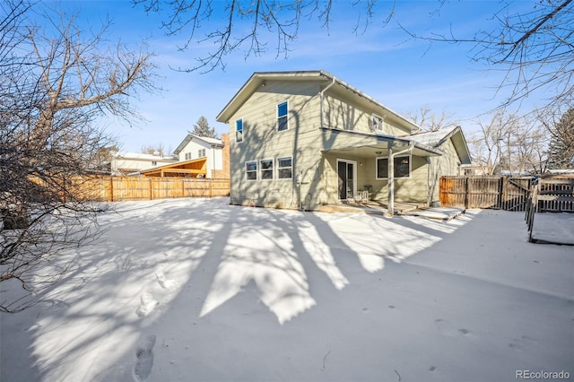 view of snow covered back of property