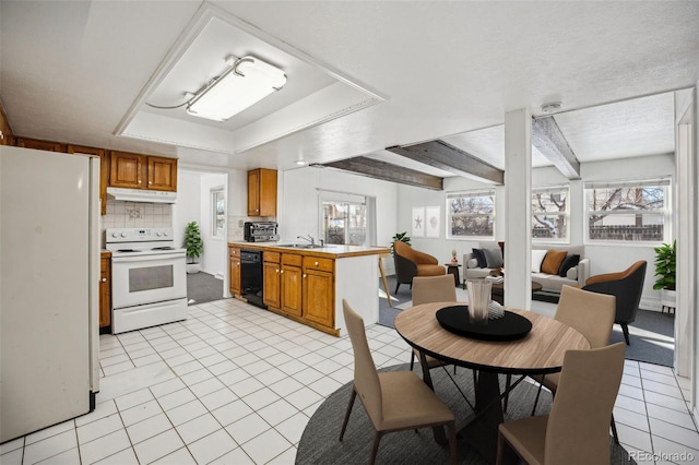 kitchen with sink, decorative backsplash, light tile patterned floors, kitchen peninsula, and white appliances