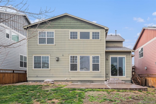 rear view of house featuring a patio and fence