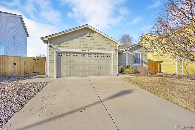 ranch-style house featuring concrete driveway, an attached garage, and fence