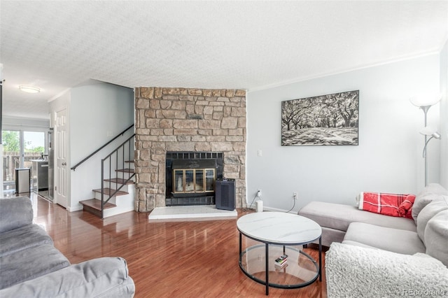 1622 S Idalia Cir Unit E, Aurora, CO 80017 - living room with stairs, wood finished floors, a stone fireplace, crown molding, and baseboards