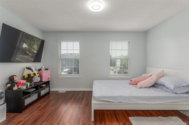 1622 S Idalia Cir Unit E, Aurora, CO 80017 - bedroom with multiple windows, dark wood-style floors, a textured ceiling, and baseboards