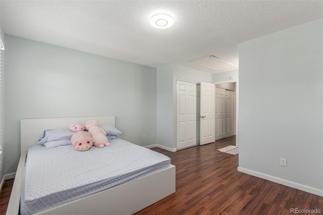 1622 S Idalia Cir Unit E, Aurora, CO 80017 - bedroom featuring dark wood-style floors, baseboards, attic access, a textured ceiling, and a closet
