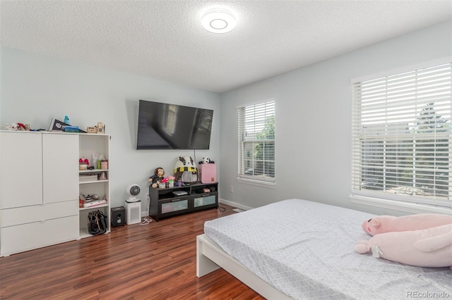 1622 S Idalia Cir Unit E, Aurora, CO 80017 - bedroom featuring dark wood-type flooring, a textured ceiling, and baseboards