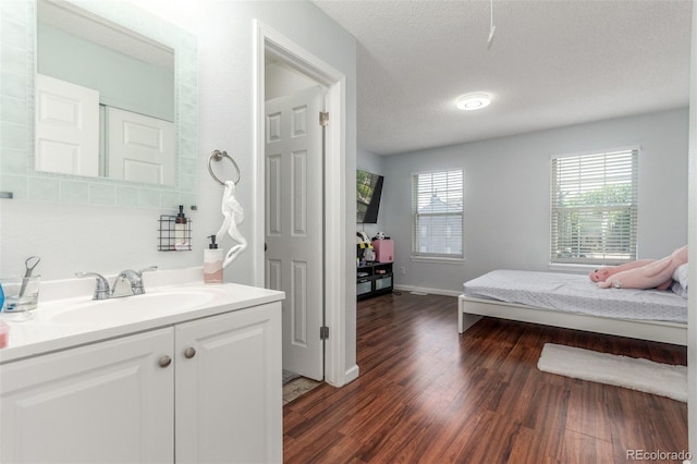 1622 S Idalia Cir Unit E, Aurora, CO 80017 - bedroom featuring a sink, dark wood-style flooring, and a textured ceiling