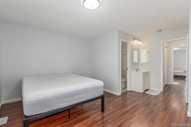 1622 S Idalia Cir Unit E, Aurora, CO 80017 - bedroom with baseboards, dark wood-style flooring, and ensuite bath