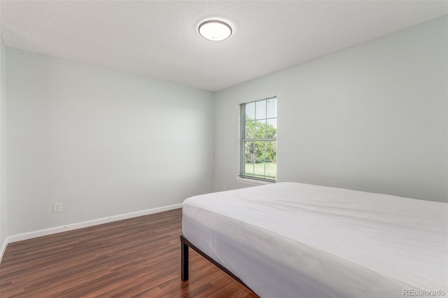 1622 S Idalia Cir Unit E, Aurora, CO 80017 - bedroom with dark wood finished floors, baseboards, and a textured ceiling