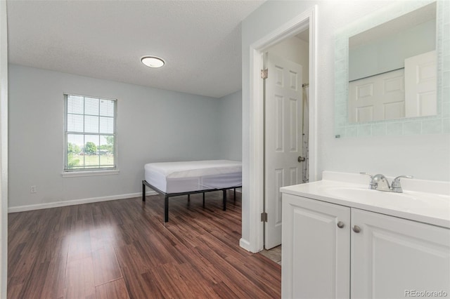 1622 S Idalia Cir Unit E, Aurora, CO 80017 - bathroom featuring wood finished floors, vanity, baseboards, and a textured ceiling