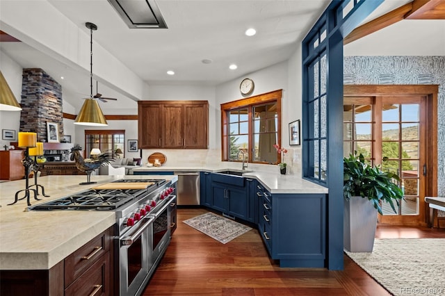 kitchen with dark wood-type flooring, sink, appliances with stainless steel finishes, pendant lighting, and ceiling fan