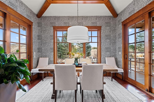 dining area with hardwood / wood-style flooring and beam ceiling