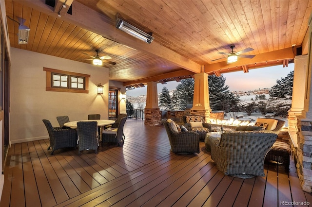 snow covered deck featuring ceiling fan and an outdoor living space with a fire pit