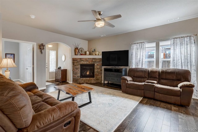 living room featuring dark hardwood / wood-style flooring, a fireplace, and ceiling fan