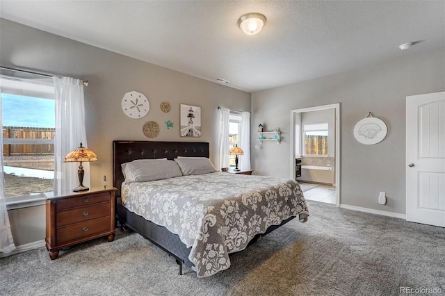 bedroom with connected bathroom and light carpet