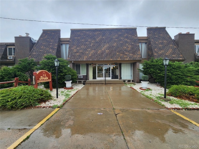 8330 Zuni St Unit 117, Denver, CO 80221 - view of front of home with roof with shingles, mansard roof, and brick siding