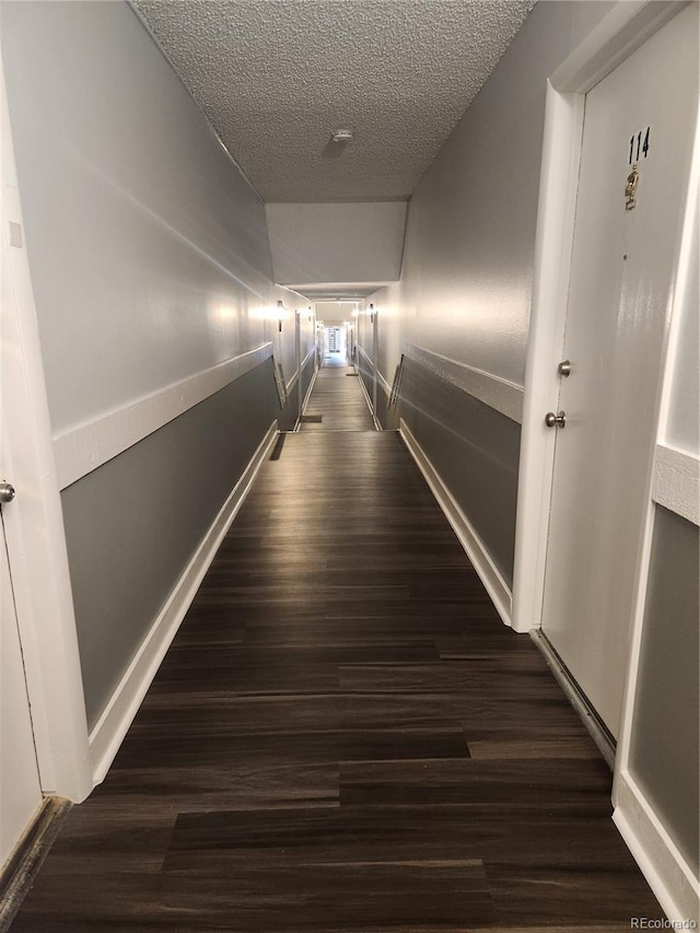 8330 Zuni St Unit 117, Denver, CO 80221 - corridor featuring dark wood finished floors, a textured ceiling, and baseboards
