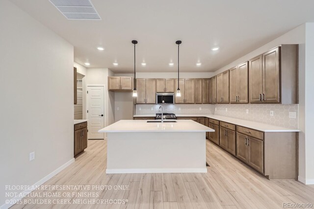 834 W 128th Pl, Westminster, CO 80234 - kitchen featuring light wood finished floors, light countertops, visible vents, a sink, and stainless steel microwave