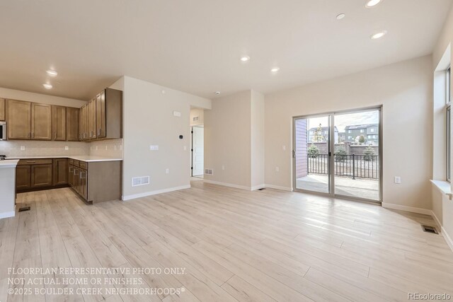 834 W 128th Pl, Westminster, CO 80234 - kitchen featuring recessed lighting, light wood finished floors, light countertops, visible vents, and decorative backsplash