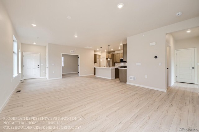 834 W 128th Pl, Westminster, CO 80234 - unfurnished living room featuring baseboards, visible vents, and light wood-style flooring