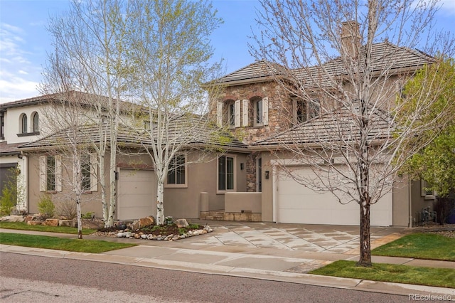 15252 W Warren Dr, Lakewood, CO 80228 - view of front of house with stucco siding, an attached garage, driveway, and stone siding
