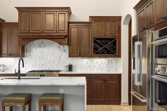 15252 W Warren Dr, Lakewood, CO 80228 - kitchen with light stone counters, a sink, backsplash, and stainless steel appliances