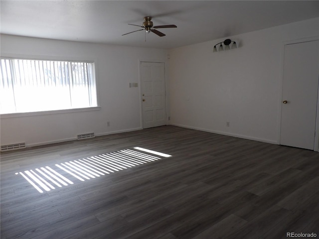 spare room featuring ceiling fan and dark wood-type flooring