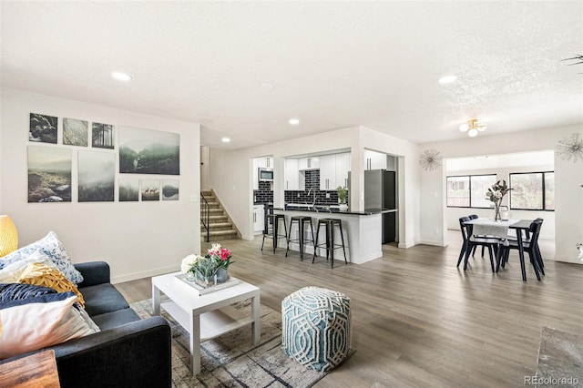 206 Troy St, Aurora, CO 80011 - living room featuring recessed lighting, light wood-style flooring, healthy amount of natural light, and stairs