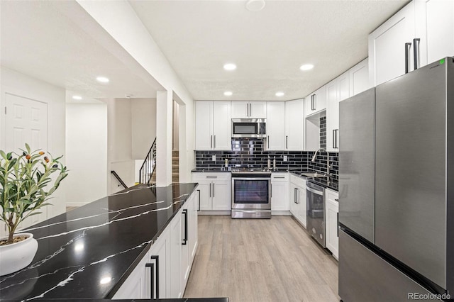 206 Troy St, Aurora, CO 80011 - kitchen with stainless steel appliances, tasteful backsplash, white cabinets, and recessed lighting