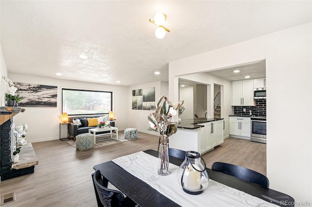 206 Troy St, Aurora, CO 80011 - dining room with a textured ceiling, light wood-style flooring, and recessed lighting