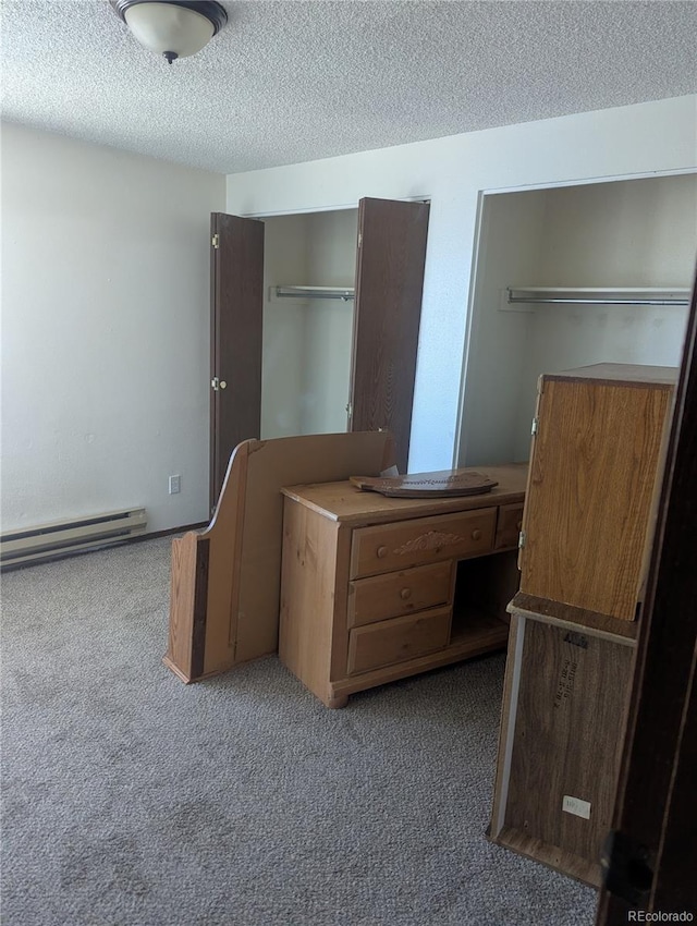 unfurnished bedroom featuring baseboard heating, a textured ceiling, and carpet flooring