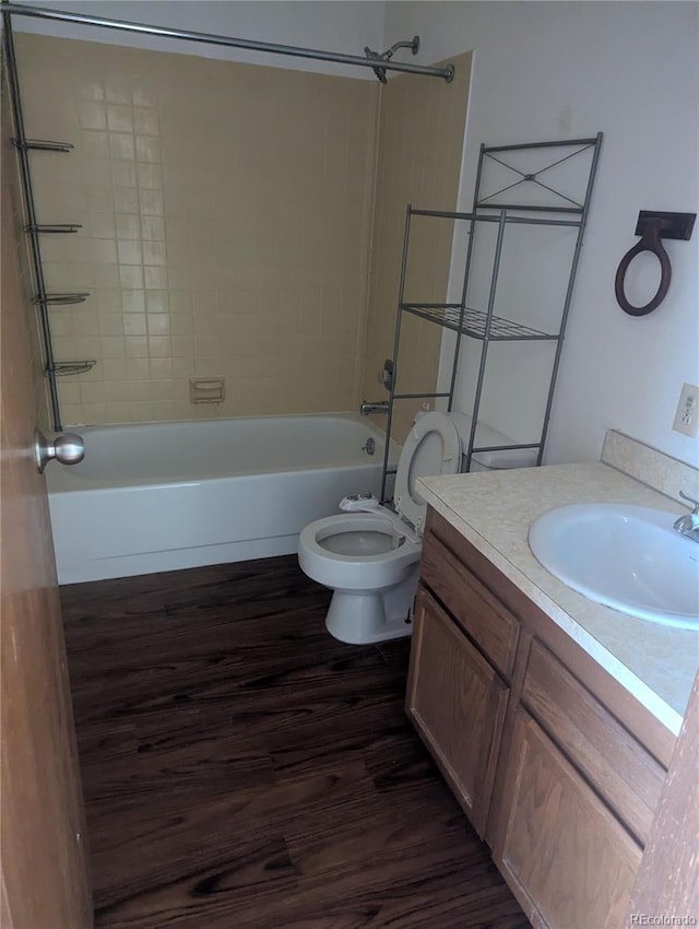 bathroom featuring toilet, washtub / shower combination, wood finished floors, and vanity