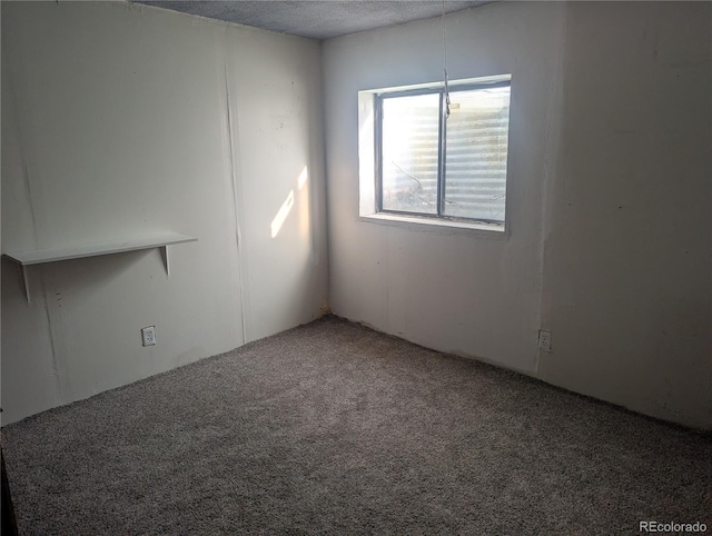 carpeted empty room featuring a textured ceiling