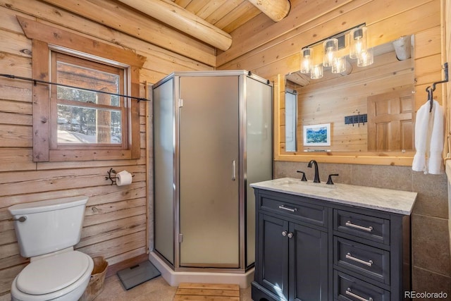 bathroom with toilet, a stall shower, wood walls, vanity, and tile patterned flooring