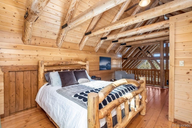 bedroom with vaulted ceiling with beams, wood walls, wooden ceiling, and light wood-style flooring