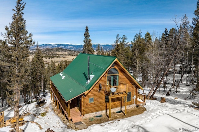 view of front of home featuring a balcony, a mountain view, and metal roof