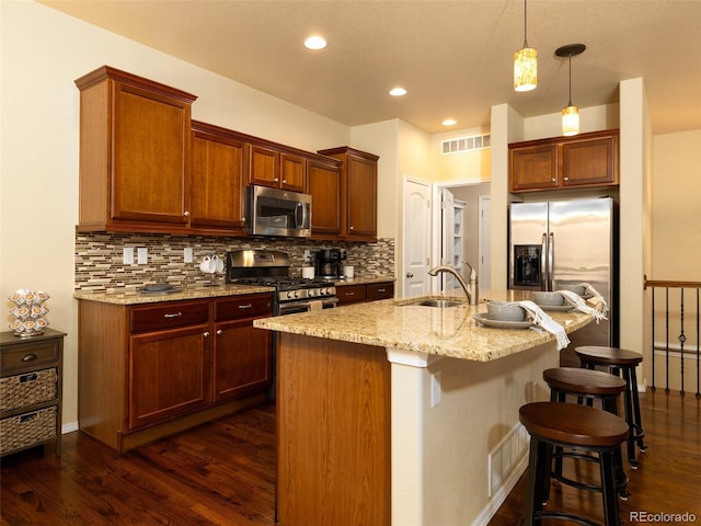 kitchen with tasteful backsplash, visible vents, dark wood-style floors, stainless steel appliances, and a sink