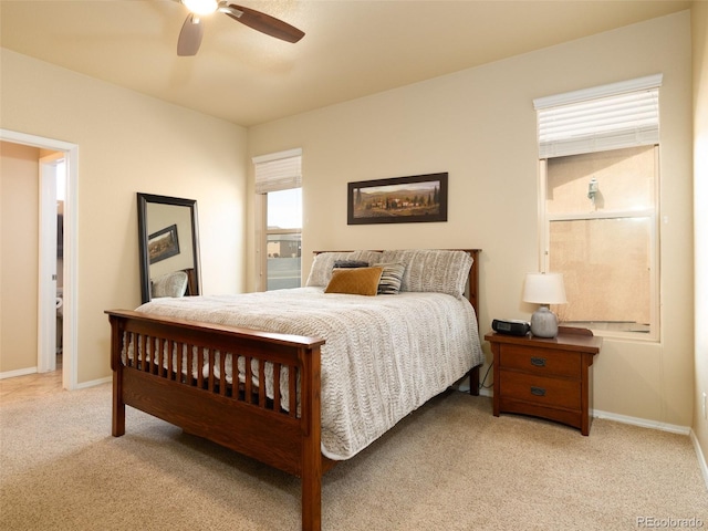 carpeted bedroom with ceiling fan and baseboards