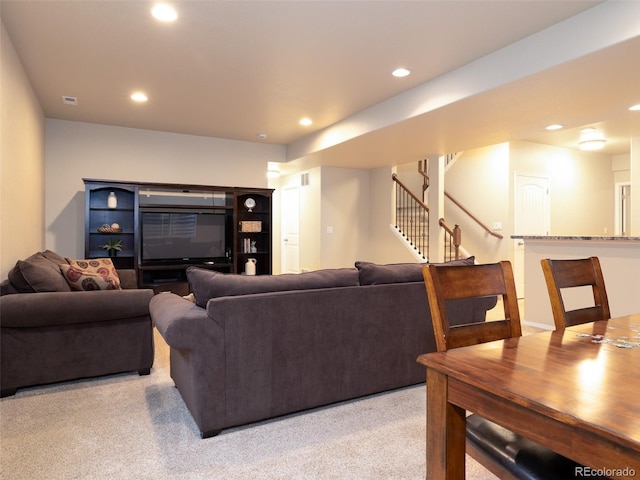 living room with stairs, visible vents, recessed lighting, and light colored carpet